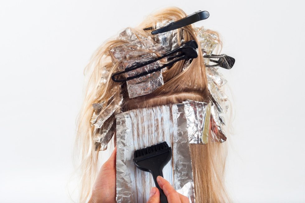 Blonde-haired woman having foil highlighting applied to hair